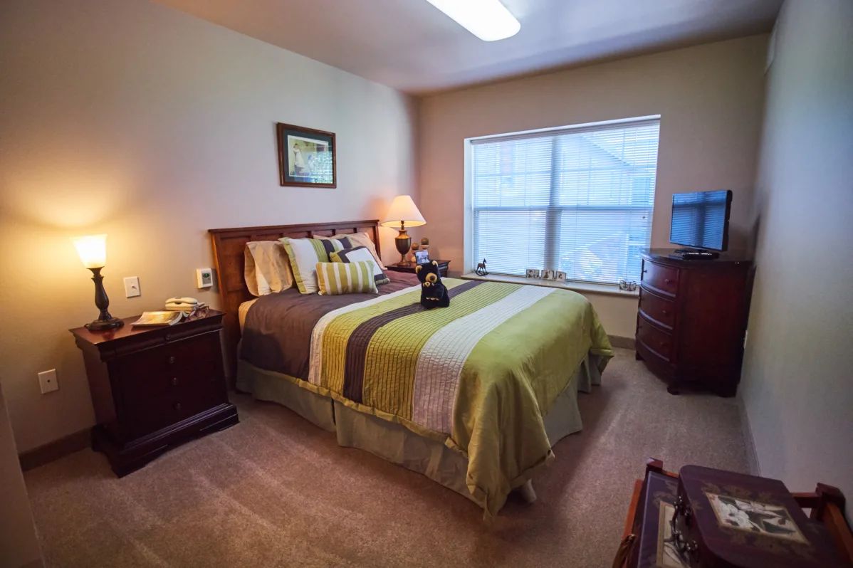 A cozy bedroom with a neatly made bed, nightstands, and soft lighting creating a warm ambiance.