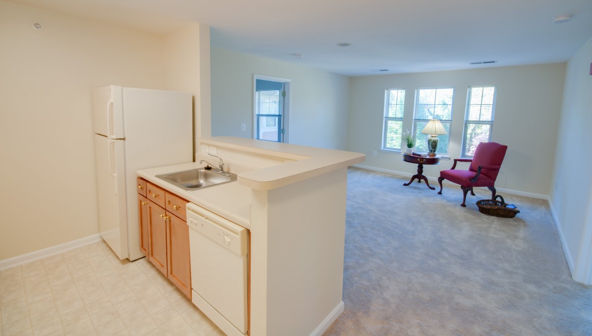 A bright and open apartment with a small kitchen and a spacious living area.