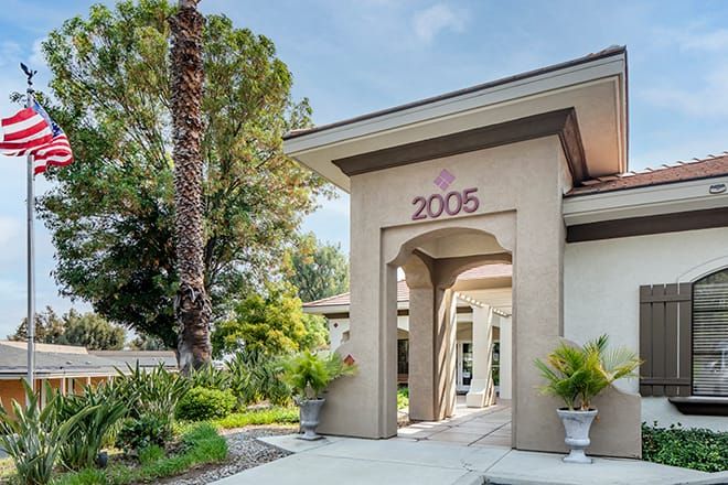 A modern house entrance with well-maintained landscaping and trees.
