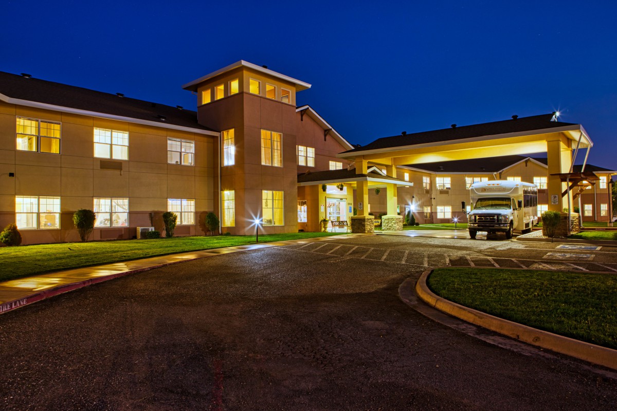 A well-lit building exterior at night, showcasing hotel architecture and entrance.