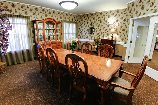 A beautifully arranged dining room featuring an elegant wooden table and chairs, adorned with floral wallpaper.