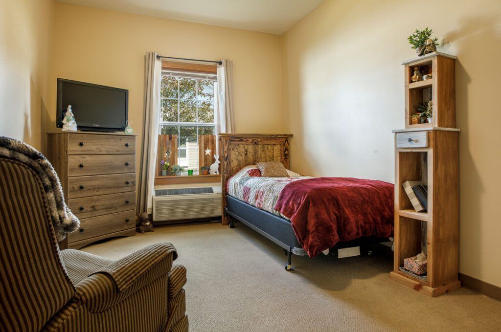 Cozy bedroom with a single bed, dresser, and television.