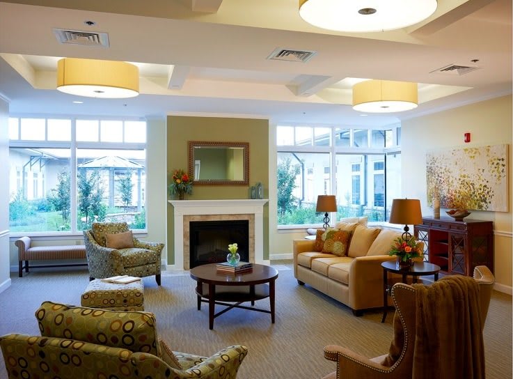 A cozy and elegantly decorated living room featuring comfortable seating and a fireplace.