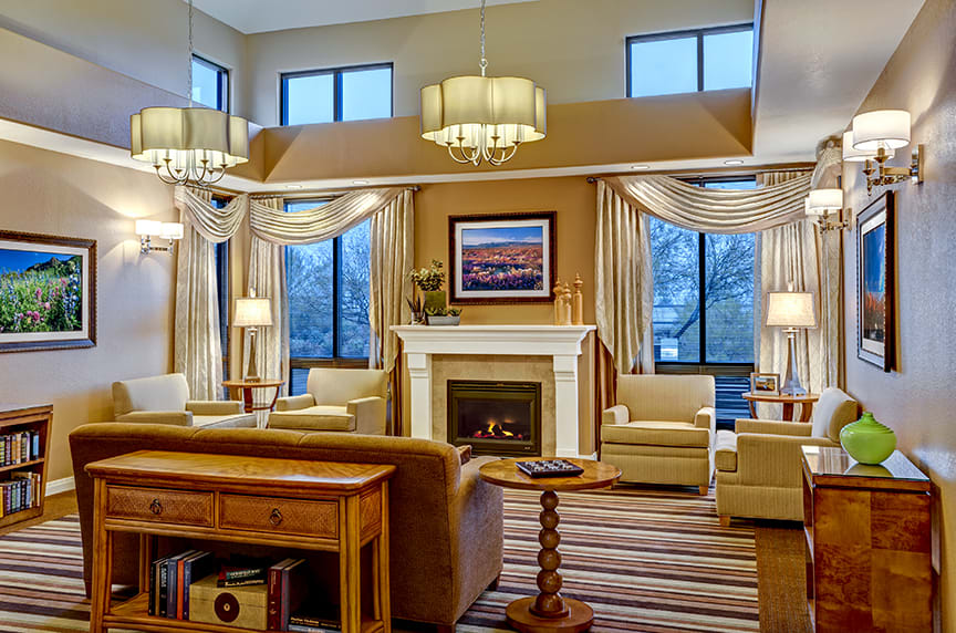 A cozy and elegantly designed living room with a fireplace, large windows, and stylish lighting.