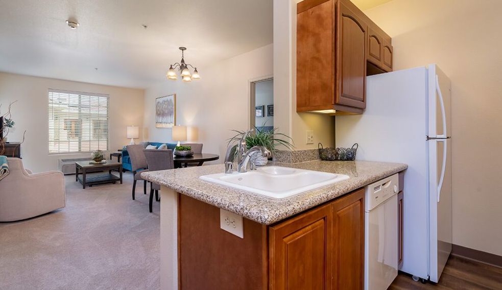 A cozy kitchen and dining area featuring wooden cabinets, a sink, and a well-lit space.