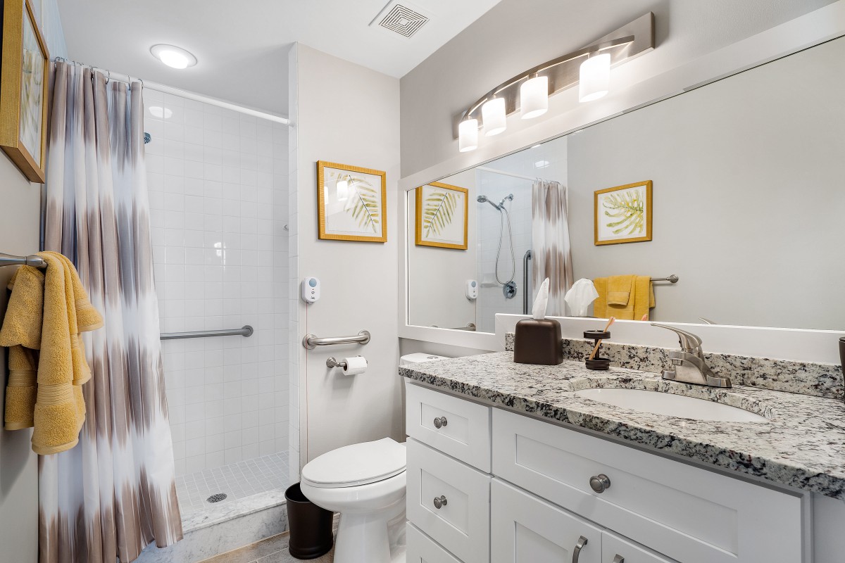 A modern bathroom featuring a shower, sink, and toilet with elegant decor.