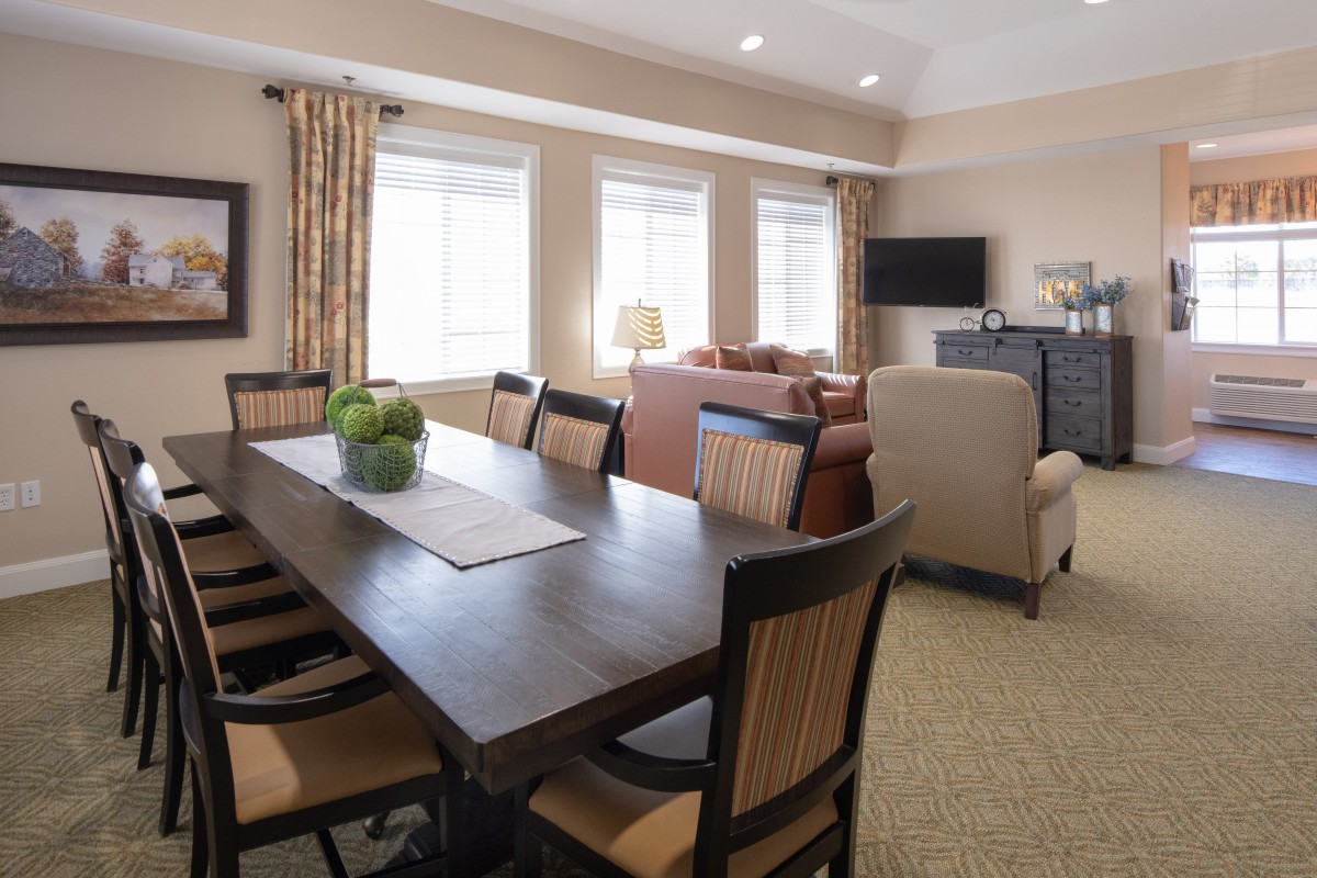 A spacious dining area connected to a living room with modern furnishings and natural lighting.