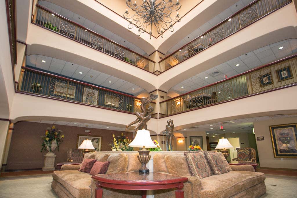 A spacious and elegant hotel lobby with seating area and chandelier.
