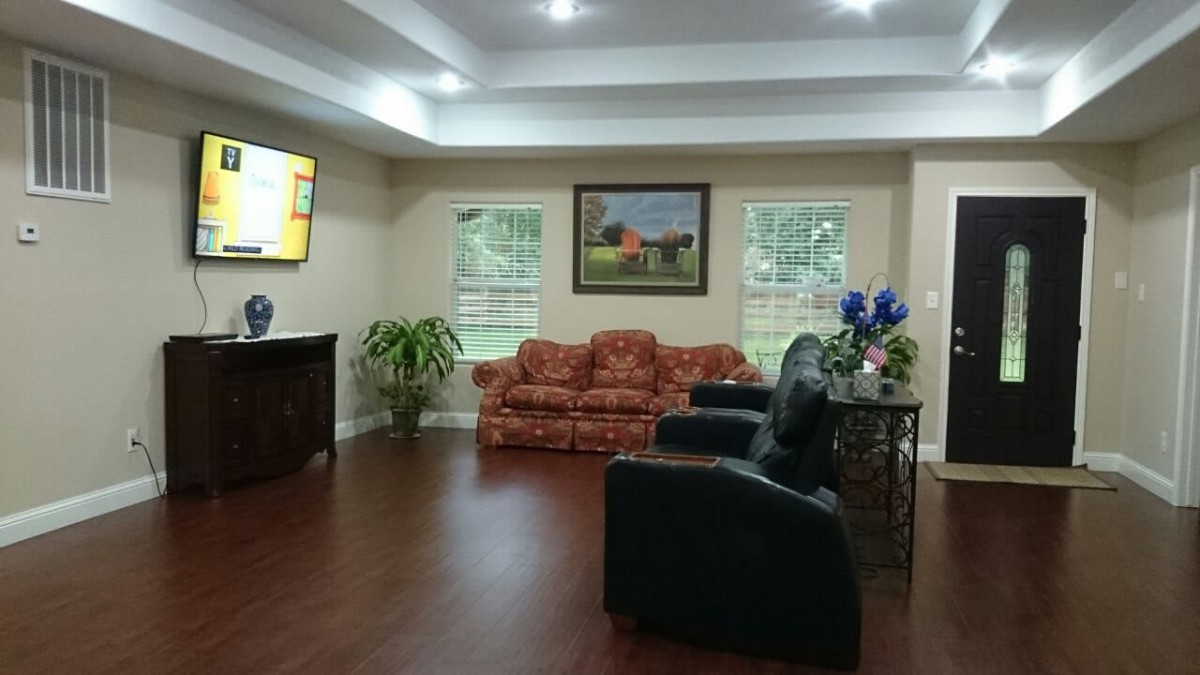 A cozy living room with a sofa, chairs, and a television.