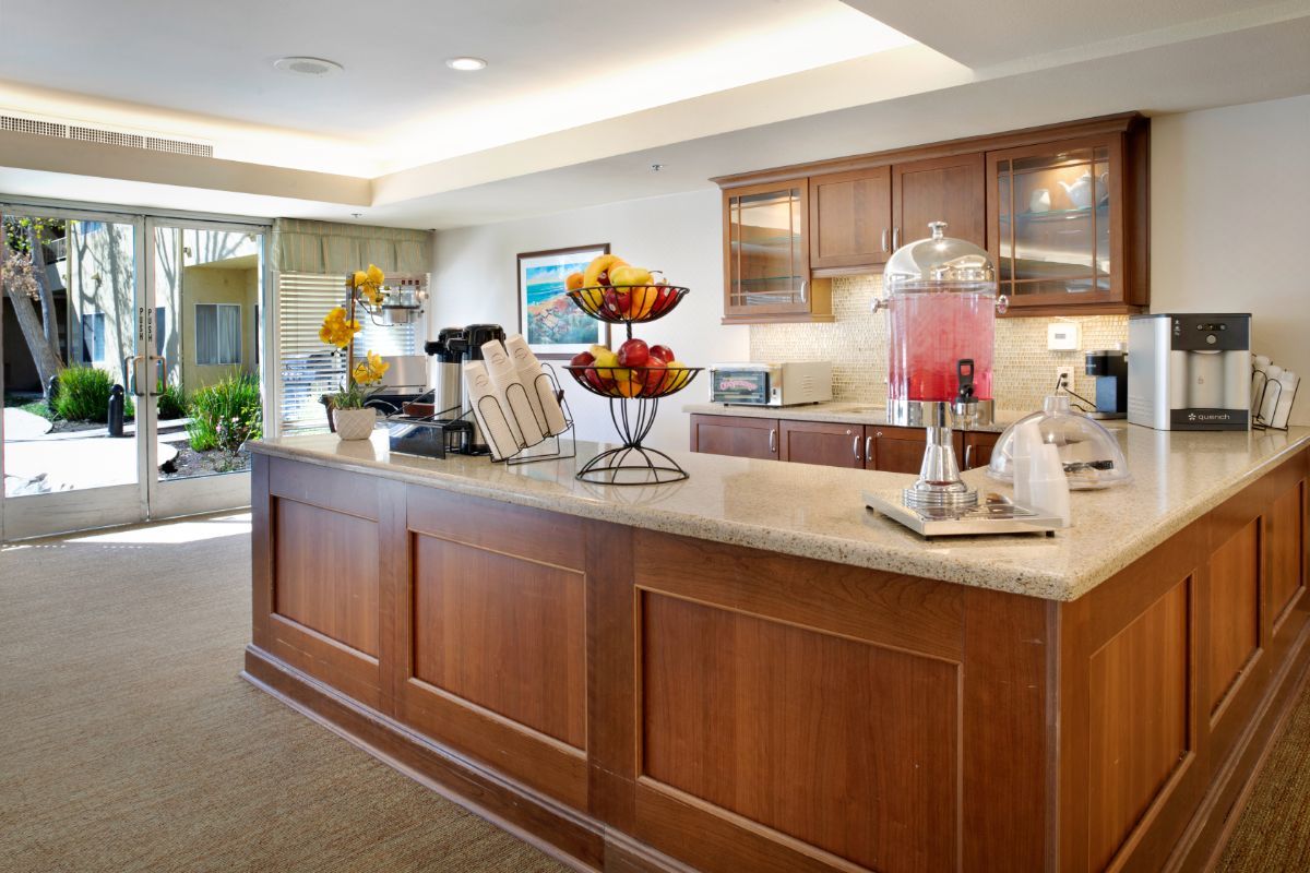 A hotel lobby reception area with a beverage station offering refreshments.
