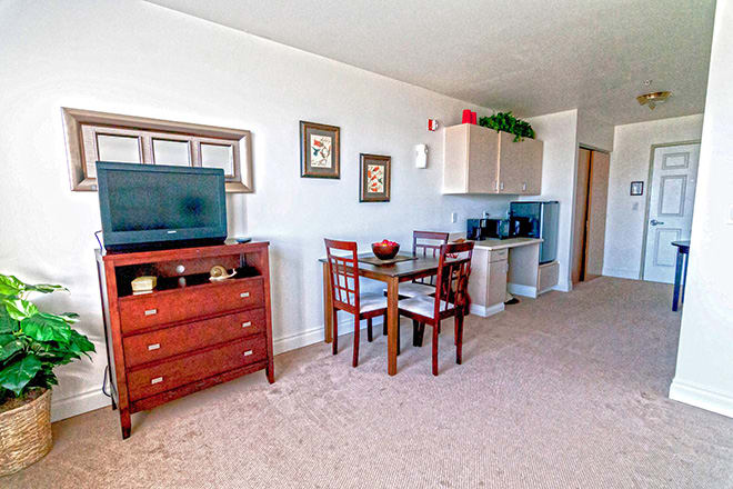 A cozy living room with a TV, dining area, and tasteful decor.
