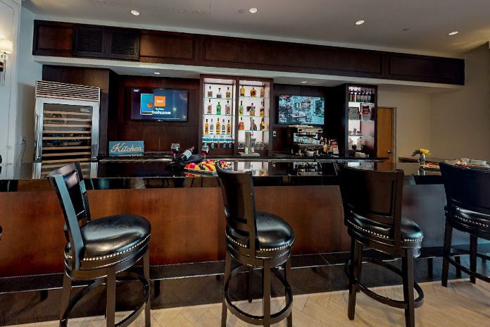 A modern bar interior with high stools and a well-stocked counter.