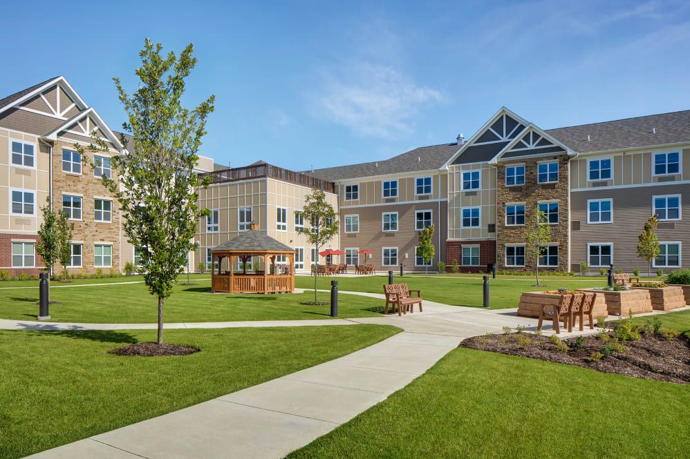 A residential building with a well-maintained lawn and outdoor seating areas.
