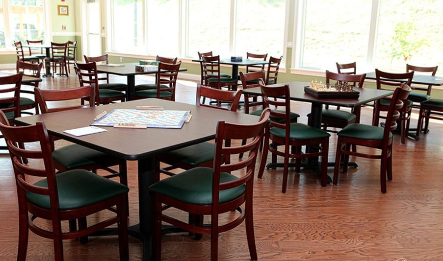 An empty restaurant dining area with wooden chairs and tables.