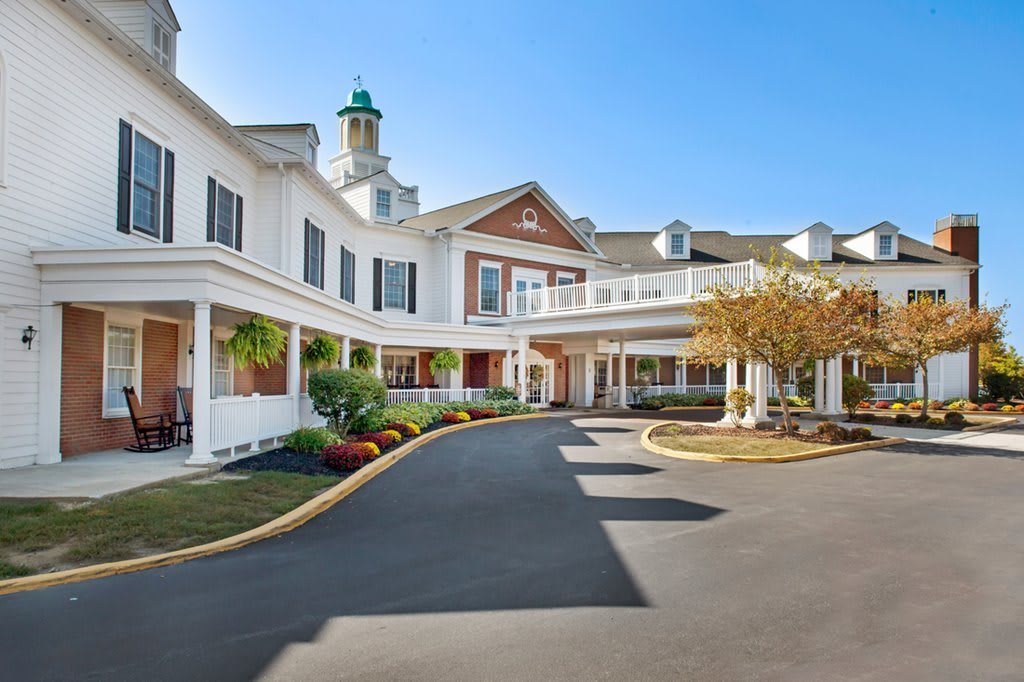 A welcoming entrance to a large residential building with detailed landscaping.
