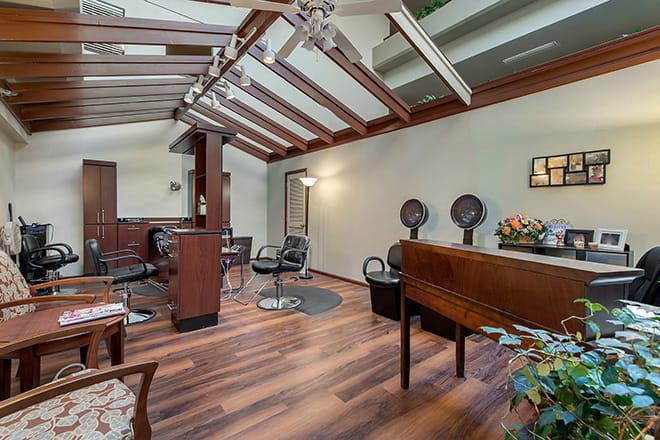 A stylish salon interior with wooden flooring and modern amenities.