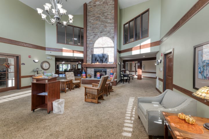 A spacious lobby featuring a central fireplace with comfortable seating and large windows.