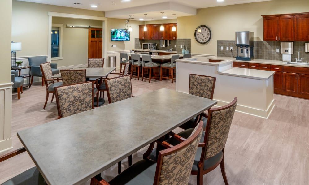 A modern meeting room with a conference table and adjacent kitchen area.