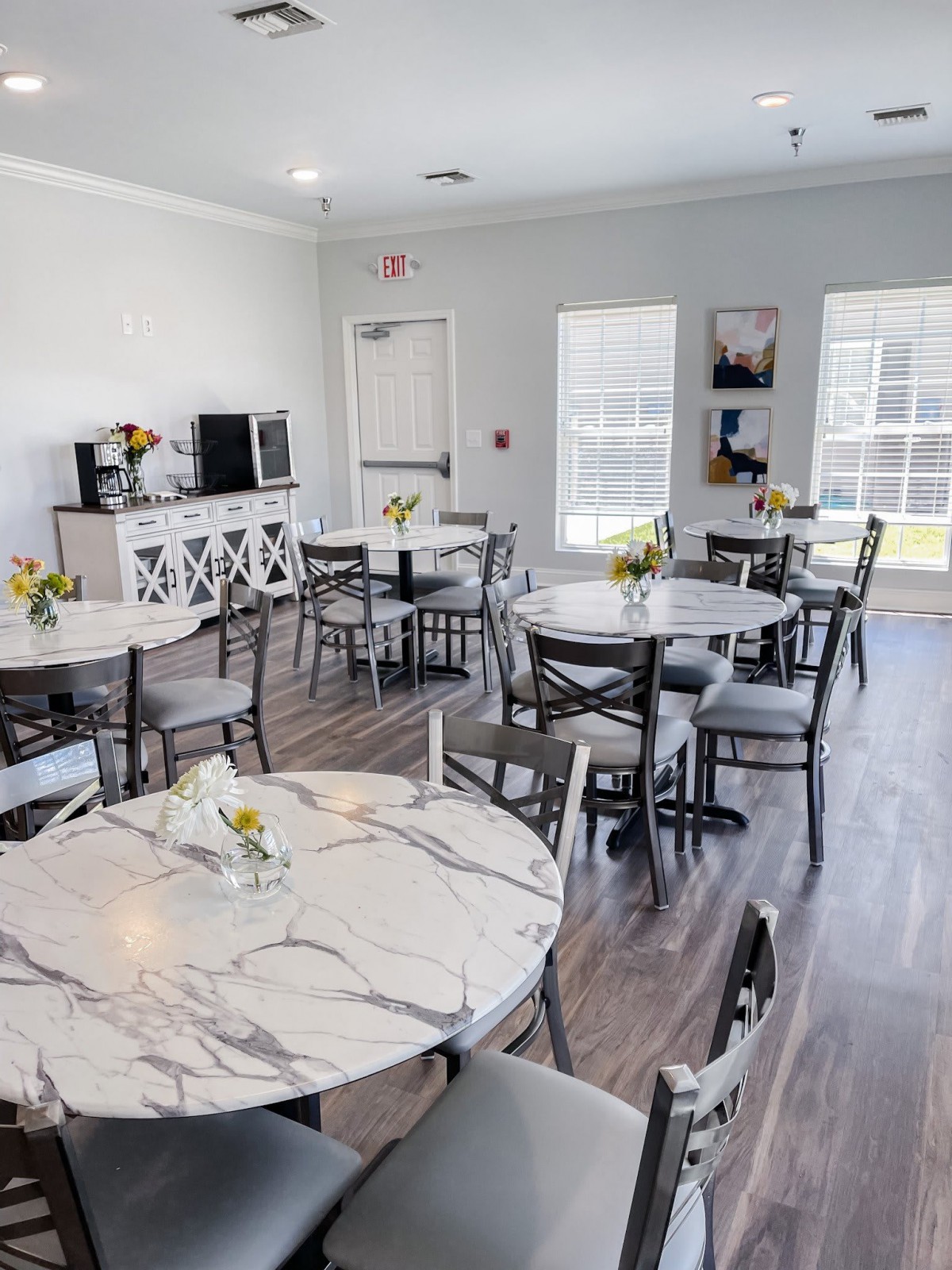 Bright and inviting dining area with marble tables and floral decorations.