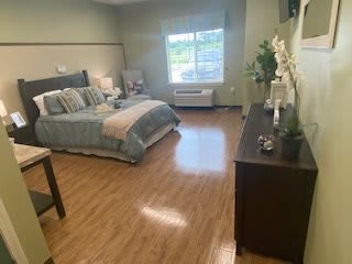 A cozy bedroom with a large bed, wooden flooring, and elegant decor.