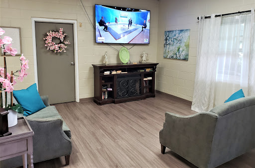 A cozy living room featuring comfortable seating, a mounted television, and stylish decor.