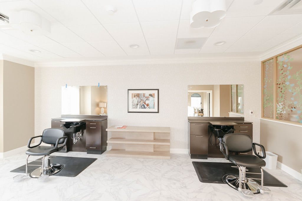 A bright and modern salon interior featuring hairdressing stations with mirrors and chairs.