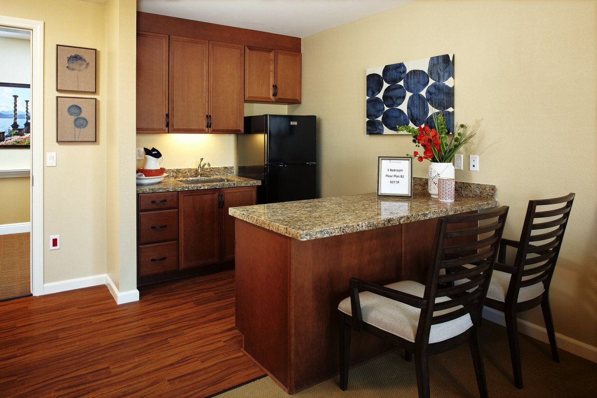 A modern kitchen interior with wooden cabinets and a granite countertop.