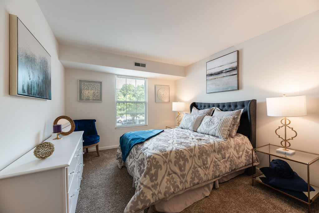 A cozy bedroom with elegant decor and a large window letting in natural light.