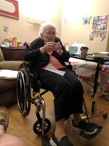 An elderly woman sitting in a wheelchair, enjoying her time indoors.