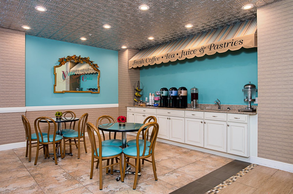 A cozy cafe with tables, chairs, and a coffee station.