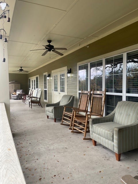 A cozy porch with rocking chairs and armchairs, perfect for relaxation.
