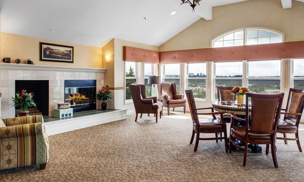 A cozy living room featuring a fireplace, ample seating, and large windows.