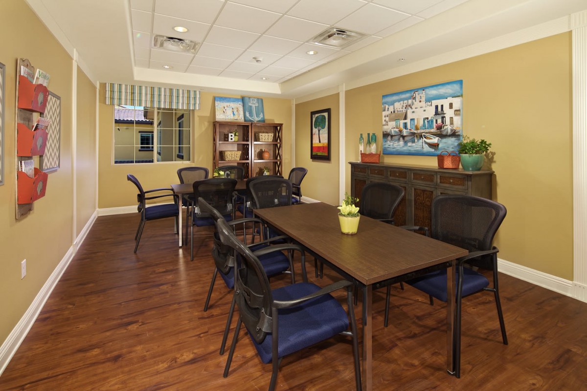 A well-furnished meeting room with a large conference table, chairs, and artwork on the walls.