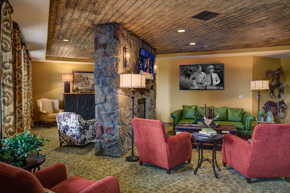 A cozy living room with comfortable seating and a stone fireplace.