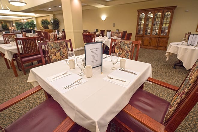 A neatly set dining table in a formal restaurant setting.