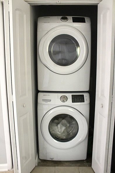 A stacked washer and dryer unit in a narrow closet space.