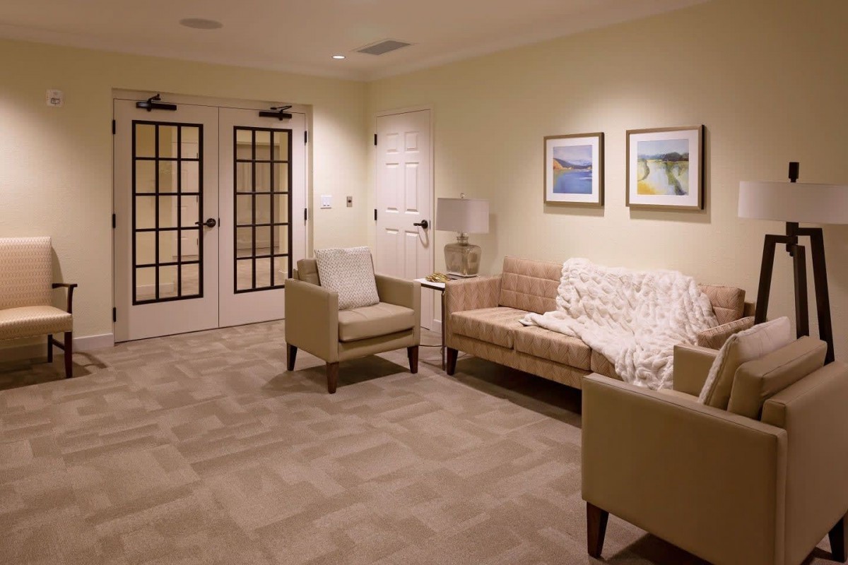 A cozy waiting room with comfortable seating and framed artwork on the walls.