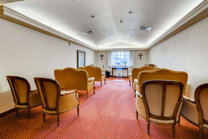 A small conference room with multiple chairs arranged facing a window.