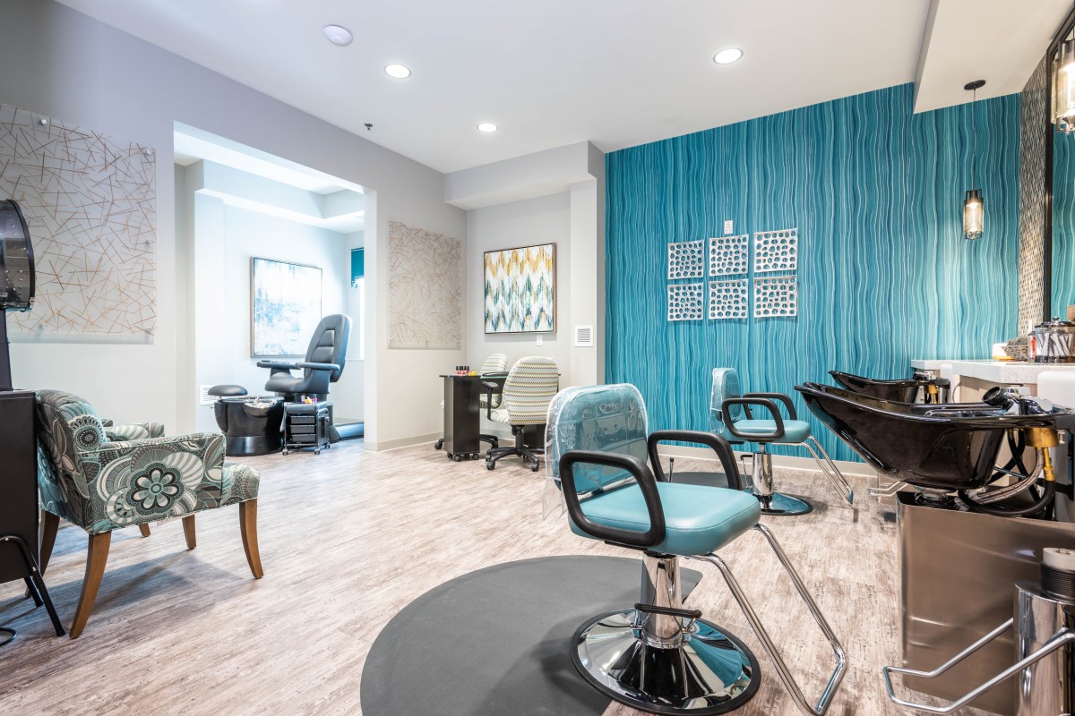 A modern hair salon with stylish blue accent walls and contemporary furnishings.