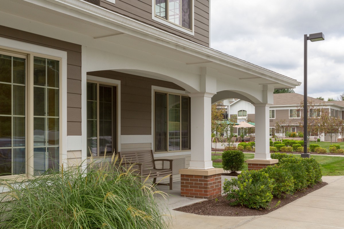A charming suburban house with a spacious front porch and well-maintained garden.