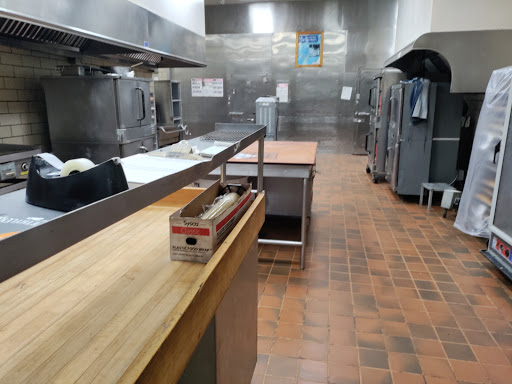 A spacious commercial kitchen featuring stainless steel surfaces and various cooking equipment.