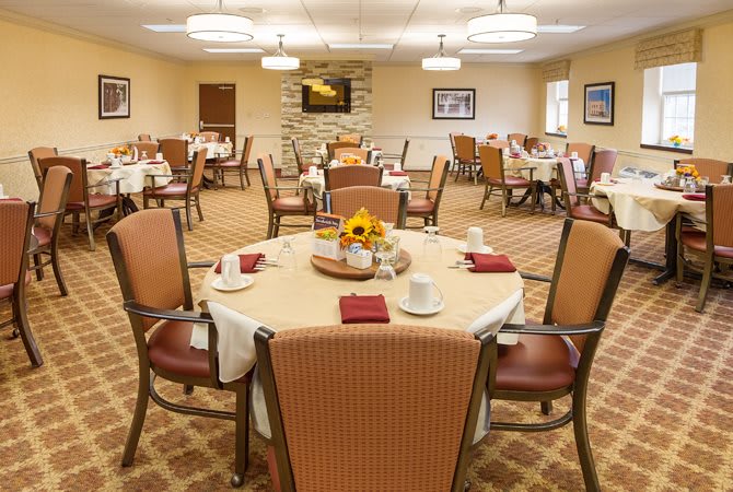 A spacious dining room with neatly arranged tables and chairs, set for a meal.