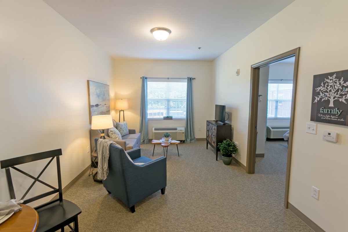 A cozy living room with comfortable furniture and a large window letting in natural light.