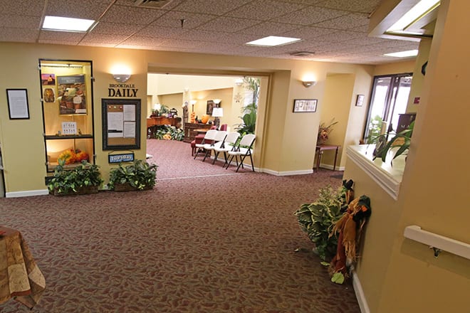 A warmly lit hallway with seating and decorative plants.