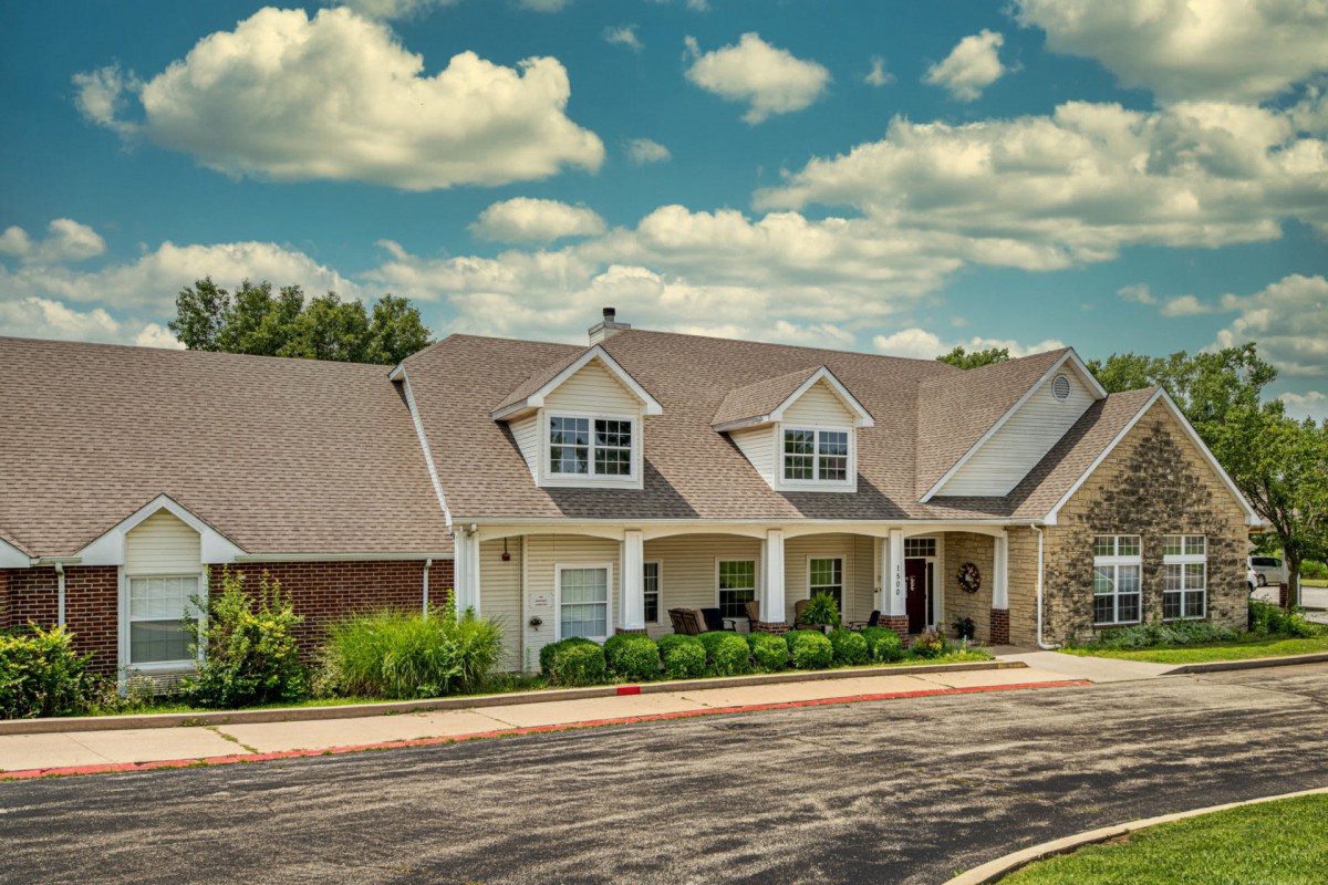 A picturesque suburban house under a partly cloudy sky.