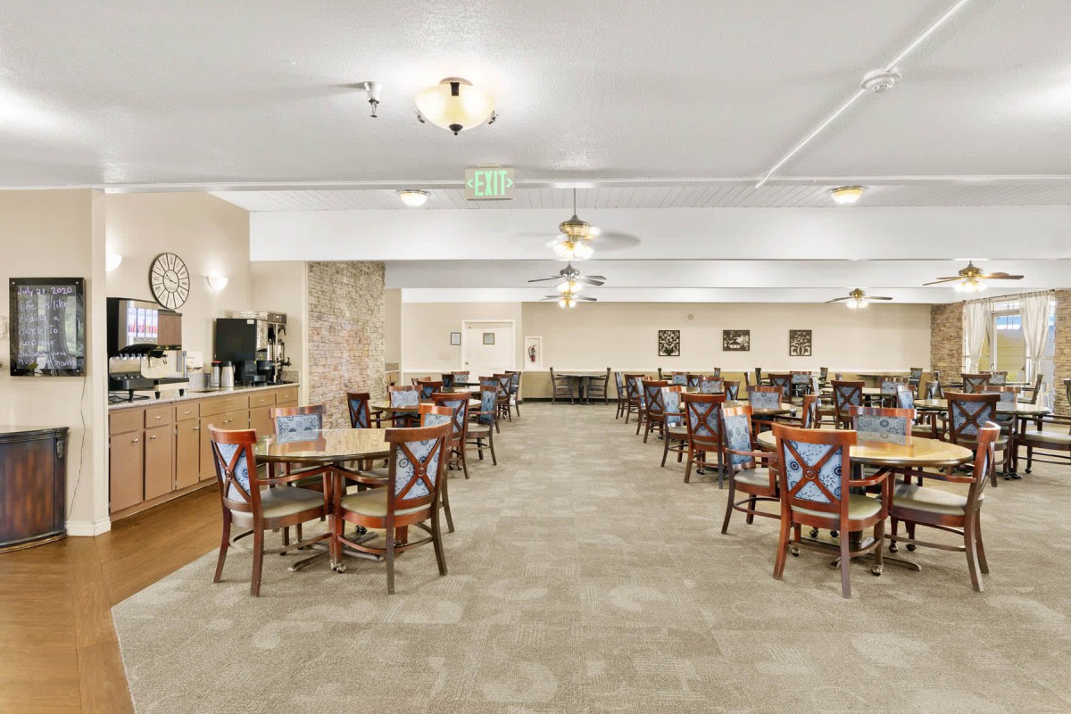 A spacious dining hall with neatly arranged tables and chairs, ambient lighting, and subtle decor.