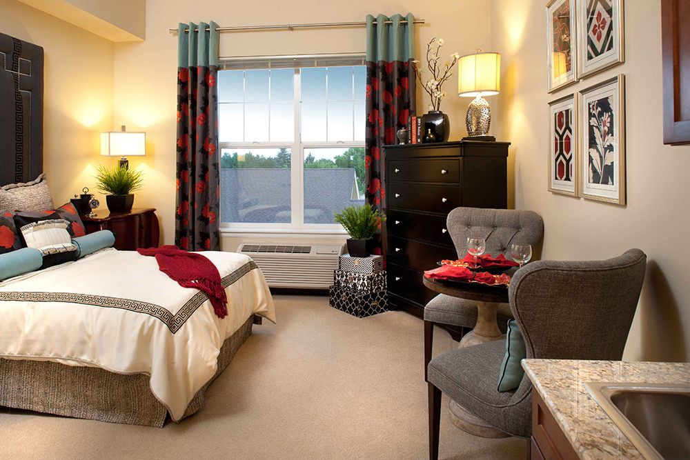 A cozy and well-decorated bedroom with a large window, featuring elegant furniture and soft lighting.