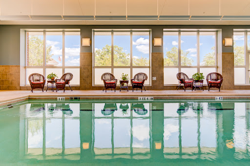 A serene indoor pool area featuring comfortable seating and large windows that bring in natural light.