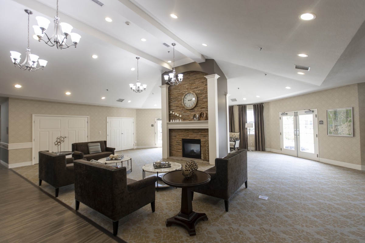 A spacious and modern living room with a central fireplace and elegant furnishings.