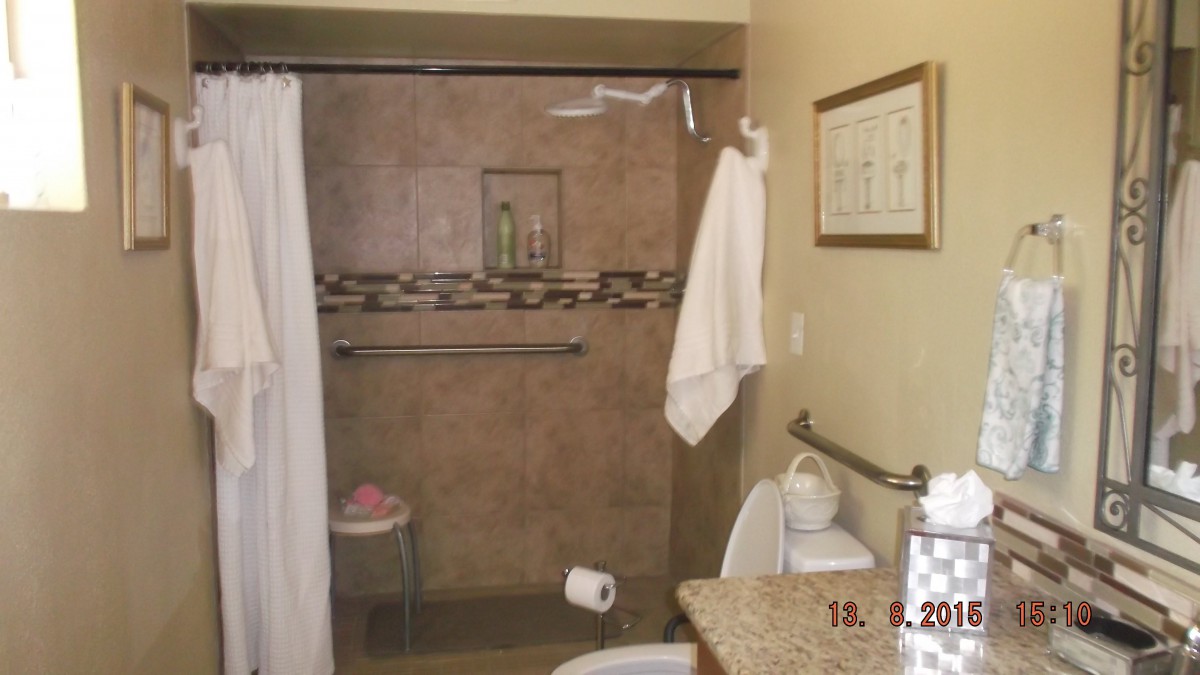 A clean and organized bathroom with a shower, towels, and toiletries.